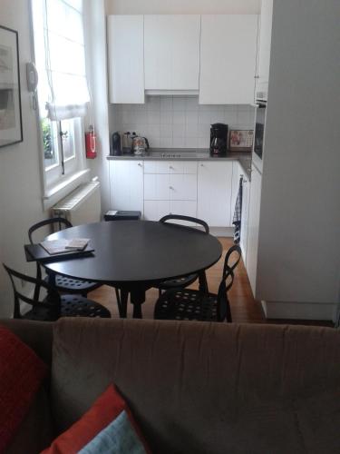 a living room with a table and chairs and a kitchen at Holiday Home Amélie in Antwerp