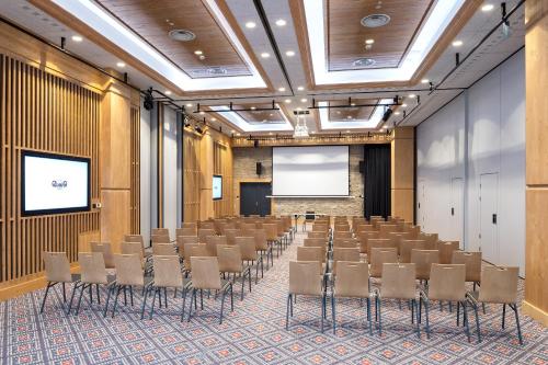 a conference room with chairs and a screen at Hotel Bania Thermal & Ski in Białka Tatrzanska