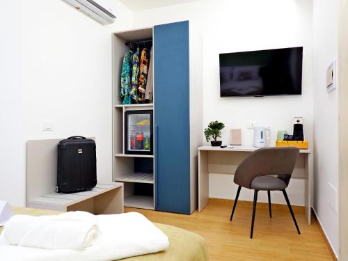 a bedroom with a desk and a chair and a tv at Casa Teresa Guest Rooms in Parghelia