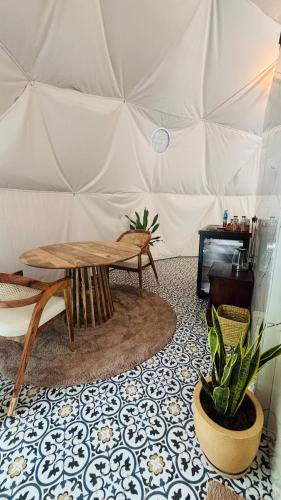 a tent with a table and a potted plant at Indulge House in Revora