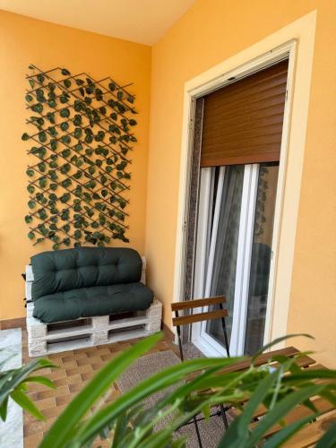 a green couch sitting in a room next to a window at Casa Teresa Guest Rooms in Parghelia