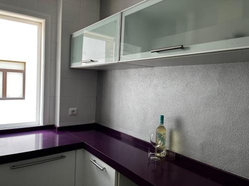 een keuken met een fles wijn op een aanrecht bij CONIL CENTRO MERCURIO solo FAMILIAS in Conil de la Frontera