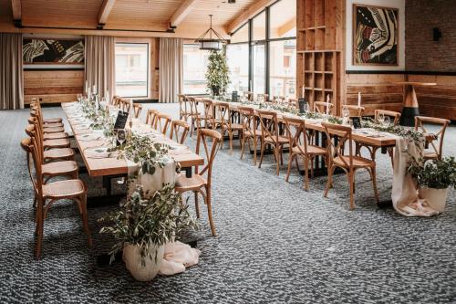 a row of tables and chairs in a room with plants at Hotel Bania Thermal & Ski in Białka Tatrzanska