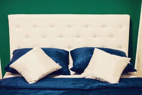 a bed with blue sheets and white pillows at Forest Central Sarajevo in Sarajevo