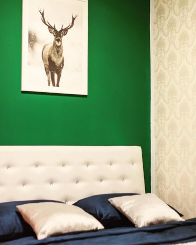 a green bedroom with a bed with a deer picture on the wall at Forest Central Sarajevo in Sarajevo