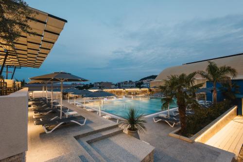a swimming pool with lounge chairs and umbrellas at Hotel Blue Moon in Ulcinj