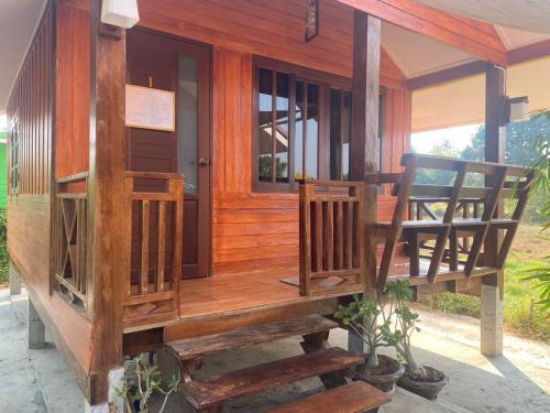 a wooden house with two chairs on a porch at สวรรค์บ้านนา คาเฟ่ ณ บ้านนา in Pakha