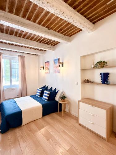 Un dormitorio con una cama azul y blanca y una ventana. en Provençal Studio - Vieil Antibes, en Antibes