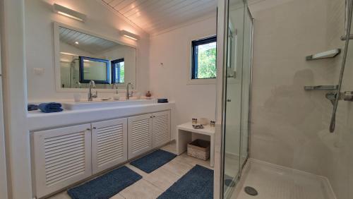 Un baño blanco con lavabo y ducha. en Blue Gem Villa, en Lefkada