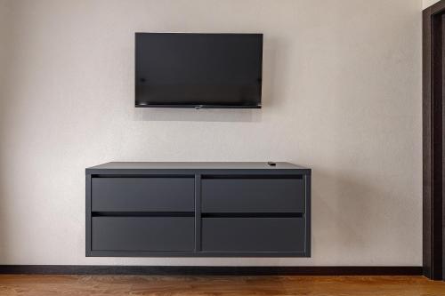a black entertainment center with a flat screen tv on a wall at Chalet 348 in Palyanytsya