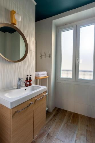 une salle de bain avec un lavabo et un miroir dans l'établissement Hôtel Maât Etoile, à Paris