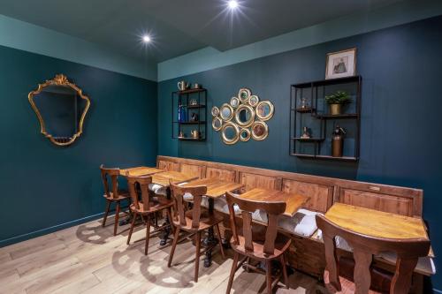 una sala da pranzo con pareti blu e tavoli e sedie in legno di Hôtel Maât Etoile a Parigi