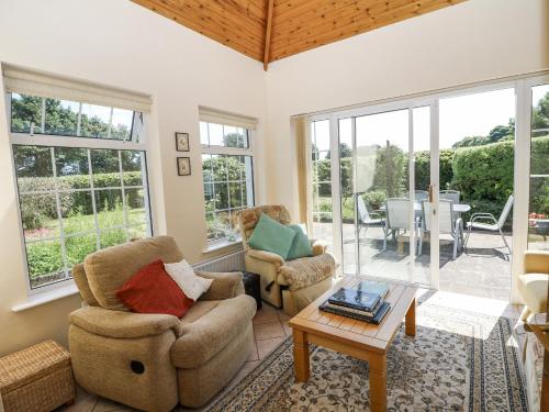 a living room with two chairs and a table at Knockroe Lodge in New Ross