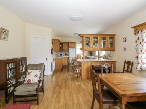 a kitchen and dining room with a table and chairs at Knockroe Lodge in New Ross