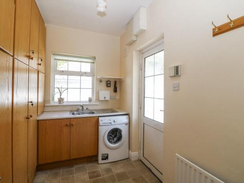 a kitchen with a washing machine and a sink at Knockroe Lodge in New Ross