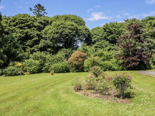 a garden with a green lawn with flowers and trees at Knockroe Lodge in New Ross
