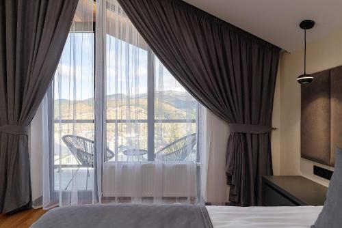 a bedroom with a large window with a balcony at Chalet 348 in Palyanytsya
