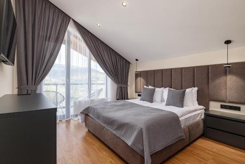 a bedroom with a large bed and a large window at Chalet 348 in Palyanytsya