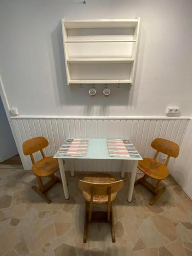a table and two chairs and a table and two shelves at Talblick in Straubenhardt