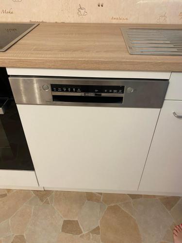 a white dishwasher in a kitchen with a counter at Talblick in Straubenhardt