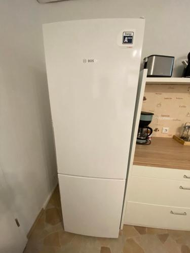 a white refrigerator in a kitchen next to a counter at Talblick in Straubenhardt