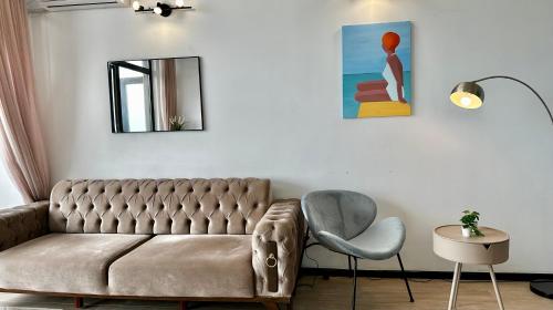 a living room with a couch and a chair at Sea Romantic Apartment in Gonio
