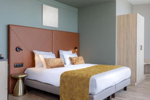 a bedroom with a large bed with white sheets at Shanghai Hotel Holland in Delft