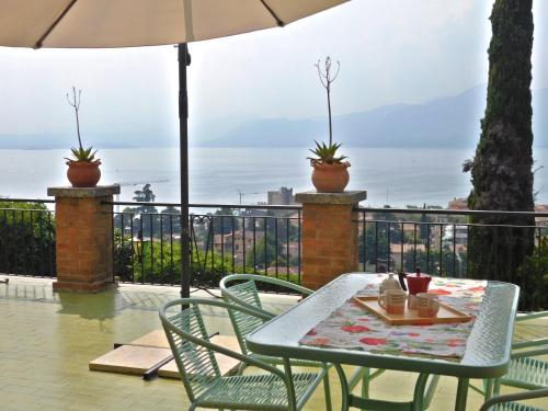 a table with chairs and an umbrella on a balcony at Villa Maria Lake View,7 minuti a piedi dal centro, parcheggio privato in Torri del Benaco