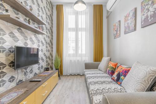 a living room with a couch and a flat screen tv at Central Six in Oradea