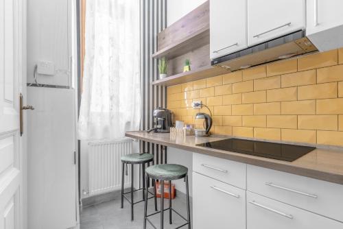 a kitchen with a counter with stools and a sink at Central Six in Oradea
