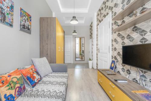 a living room with a couch and a flat screen tv at Central Six in Oradea