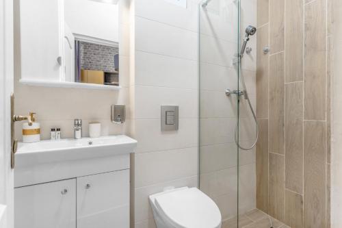 a bathroom with a shower and a toilet and a sink at Central Six in Oradea