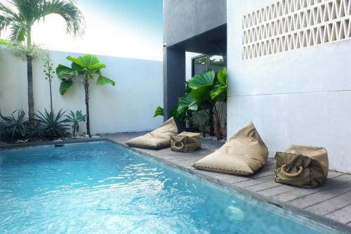 チャングーにあるHanupis Canggu Apartment Villaの枕付きのスイミングプールが隣にあります。