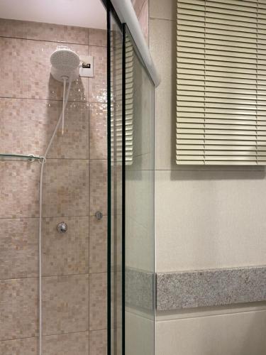 a shower with a glass door in a bathroom at Apê coração BC 1 qto 4 pess 300m Praia Garagem Priv in Balneário Camboriú