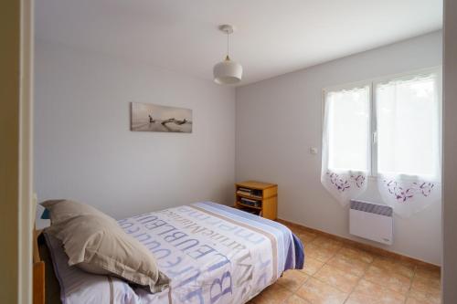 a bedroom with a bed and a window at Ty Ma Breur - 5min de la Plage in Cléden-Cap-Sizun