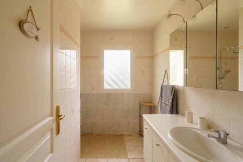 a white bathroom with a sink and a mirror at Ty Ma Breur - 5min de la Plage in Cléden-Cap-Sizun