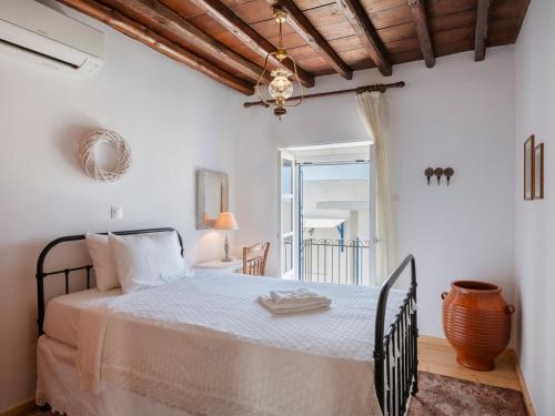 a bedroom with a bed with a table and a window at Marouso Villa - Paros Seaview Getaway in Márpissa