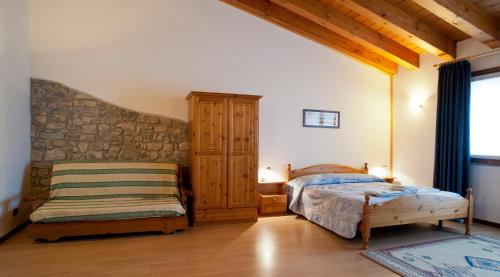 a bedroom with a bed and a bench in a room at Ai Casali in Cividale del Friuli