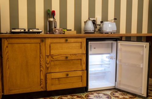 a kitchen with a counter with an open refrigerator at Mqabba Studio Flat by Talbot & Bons in Mqabba