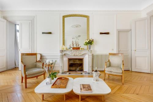 - un salon avec une cheminée, une table et des chaises dans l'établissement Luxueux duplex Elysées 240m2, à Paris