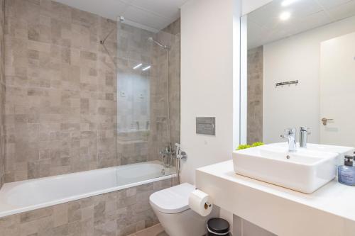a bathroom with a sink and a toilet and a tub at Beachfront Apartment 034 in Torre del Mar