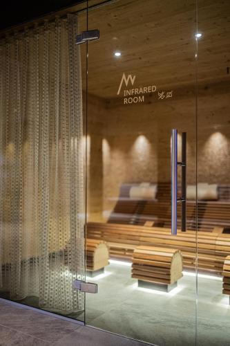 a room with a bed and a glass wall at Hotel Anewandter in Brunico