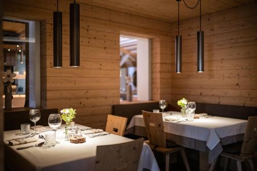 a dining room with two tables with white tablecloths at Hotel Anewandter in Brunico