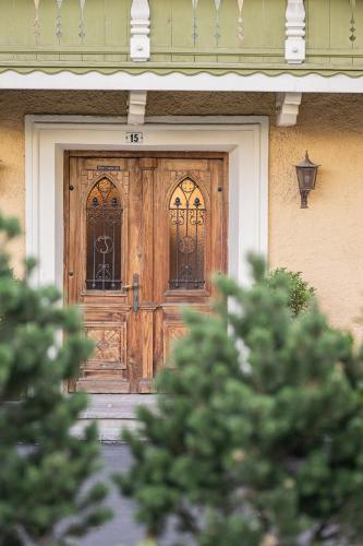a wooden door on a house with a tree at Hotel Anewandter in Brunico