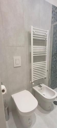 a white bathroom with a toilet and a sink at Esperia Maison B&b in Montesarchio