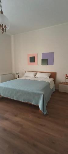 a bedroom with a bed with paintings on the wall at Esperia Maison B&b in Montesarchio