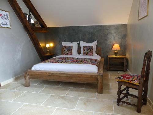 una camera da letto con un letto con due tavoli e due lampade di Le Moulin Chevillon a Cercy-la-Tour