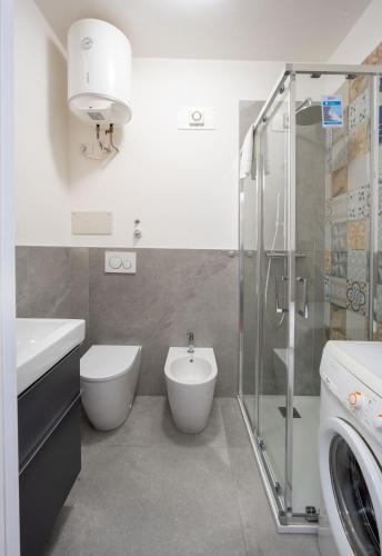 a bathroom with a toilet and a sink and a shower at L'Alicanto - Bilocale zona centro in Pordenone