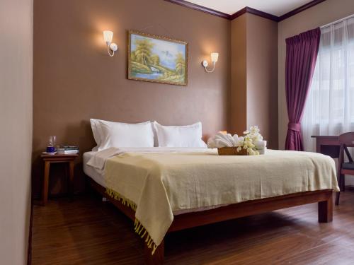 a bedroom with a large bed with white pillows at Phonethip Residence, Khouvieng in Vientiane