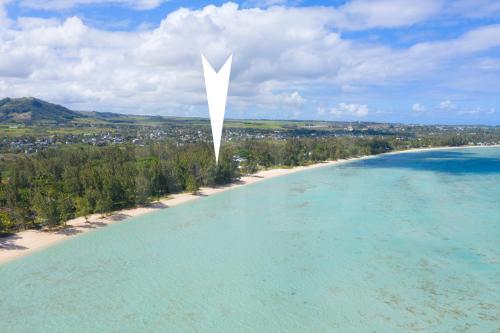 a large white pole sticking out of the water on a beach at Villa Philibert in Riambel